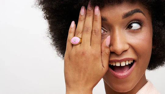 una ragazza indossa un anello sulla sua mano. L'anello di tendenza è color rosa.