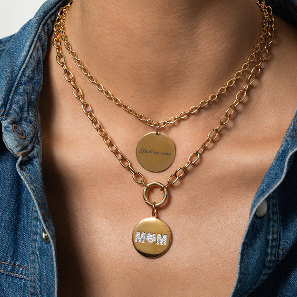 una modella indossa dei girocolli a catena e due medagliette. Una medaglia è personalizzata con la scritta 